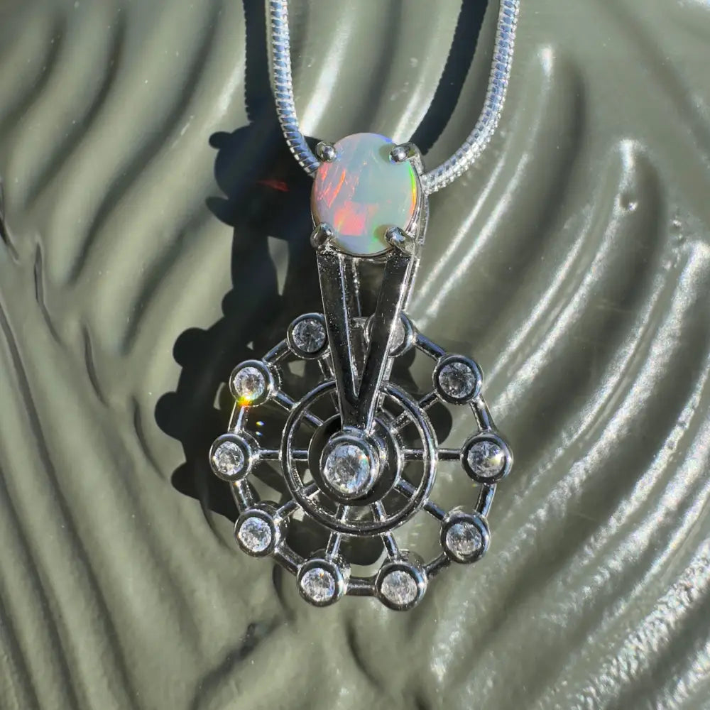 Silver spinning ferris wheel pendant with Lightning Ridge opal and diamond accents