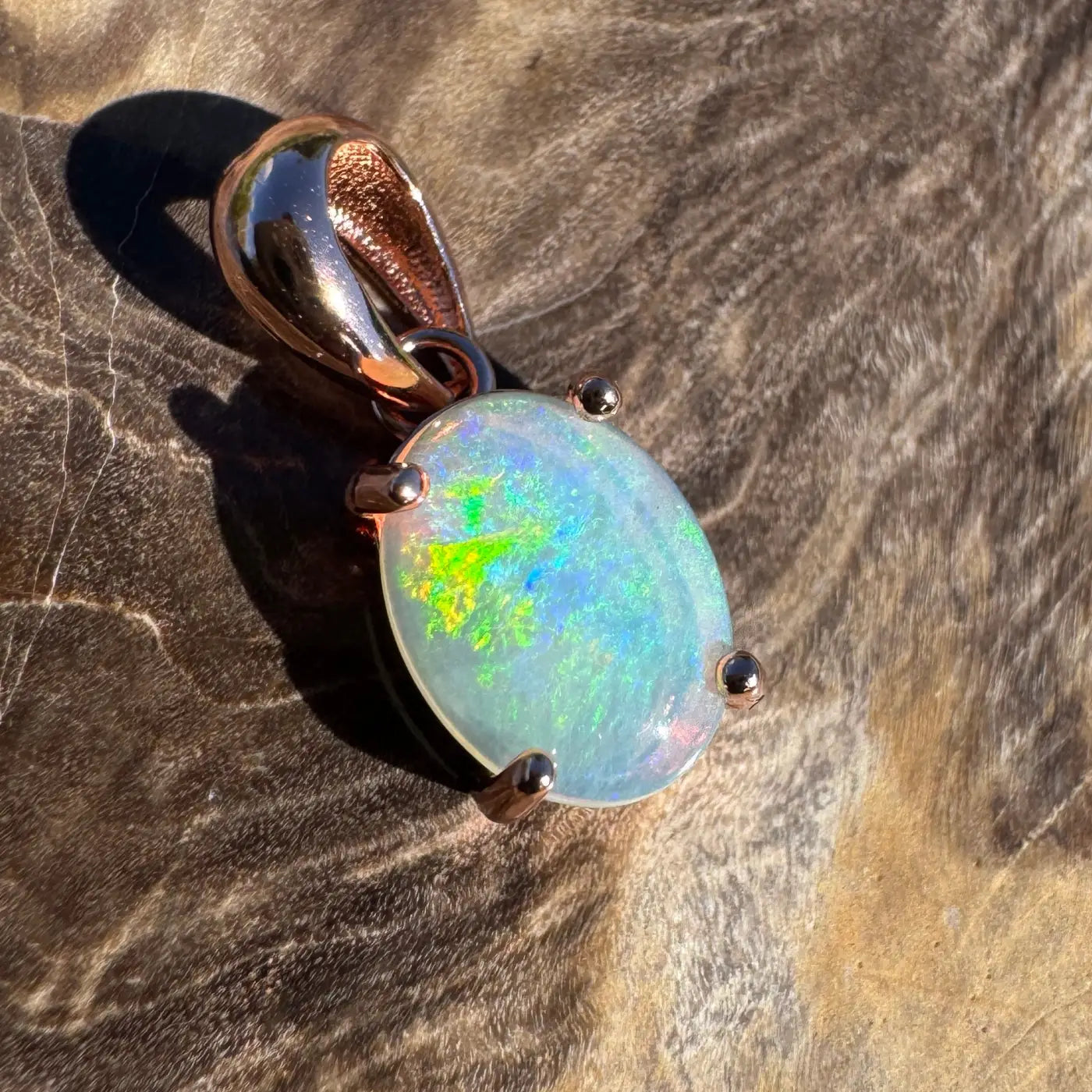 Oval opal pendant with rose gold setting in handcrafted Great Ocean Drift jewelry display