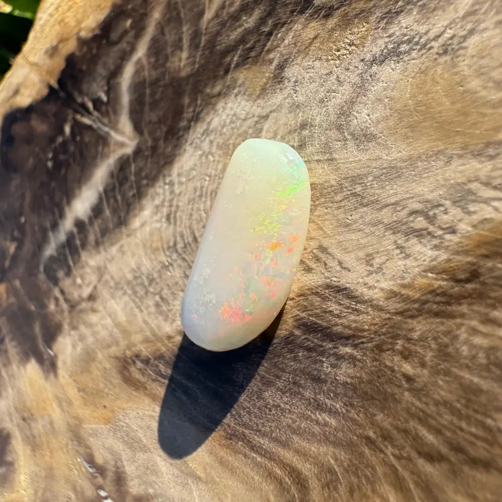 Polished white Coober Pedy opal with vibrant colorful flashes in a 2.9-carat hand-cut gemstone