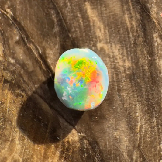 Iridescent opal cabochon displayed in Hand-Cut Solid Lightning Ridge Black Opal 0.9 carat