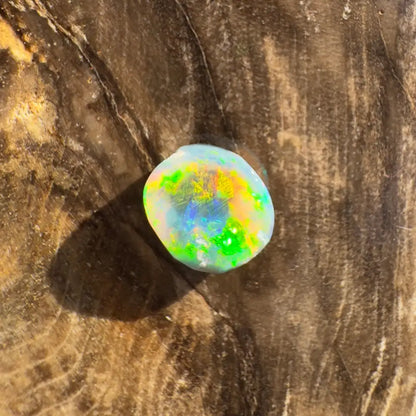 Iridescent opal cabochon displays vibrant color play in the Lightning Ridge Black Opal 0.9 carat jewelry piece