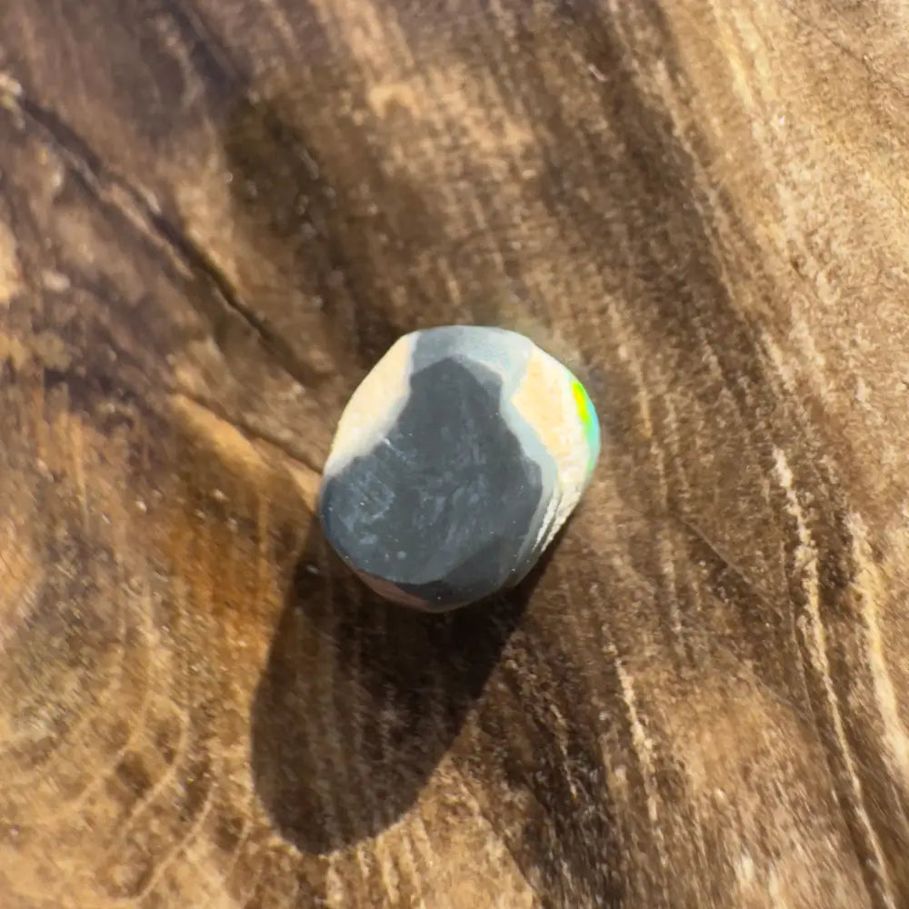 Polished Lightning Ridge Black Opal gemstone displayed in a hand-cut 0.9 carat product