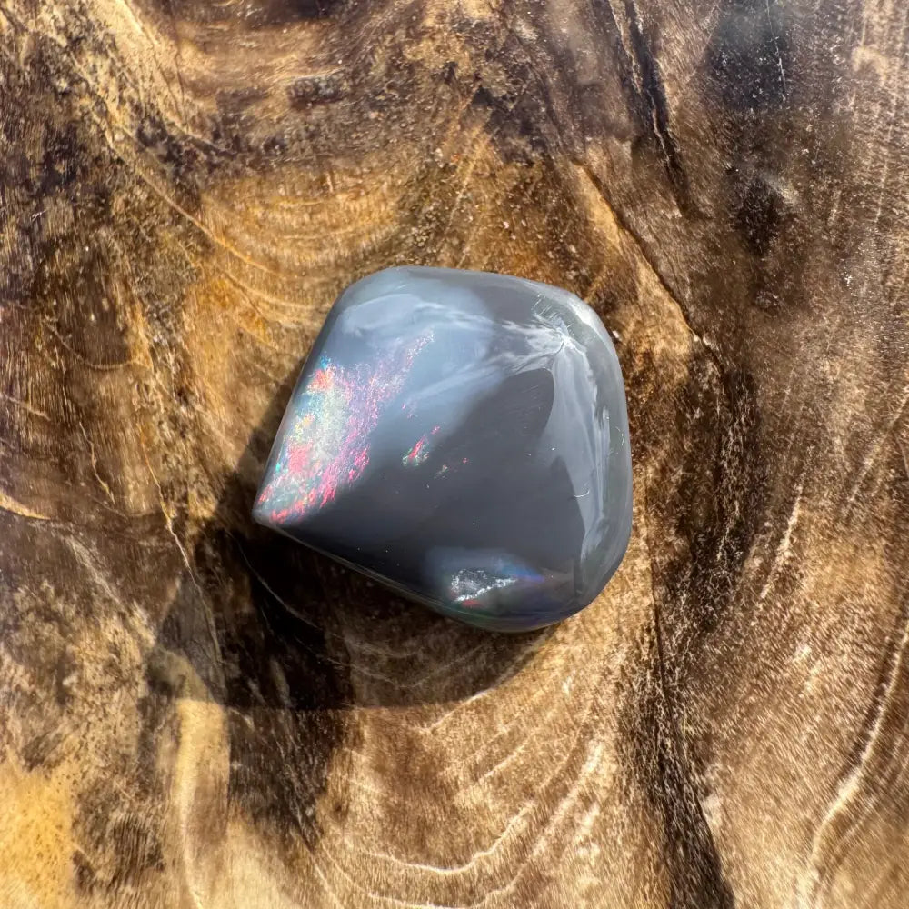 Polished gray stone with iridescent sheen from Hand-Cut Solid Lightning Ridge Black Opal 4.0carat