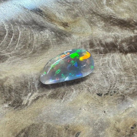 Hand-cut solid Lightning Ridge opal gemstone displaying iridescent colors and vibrant play of light