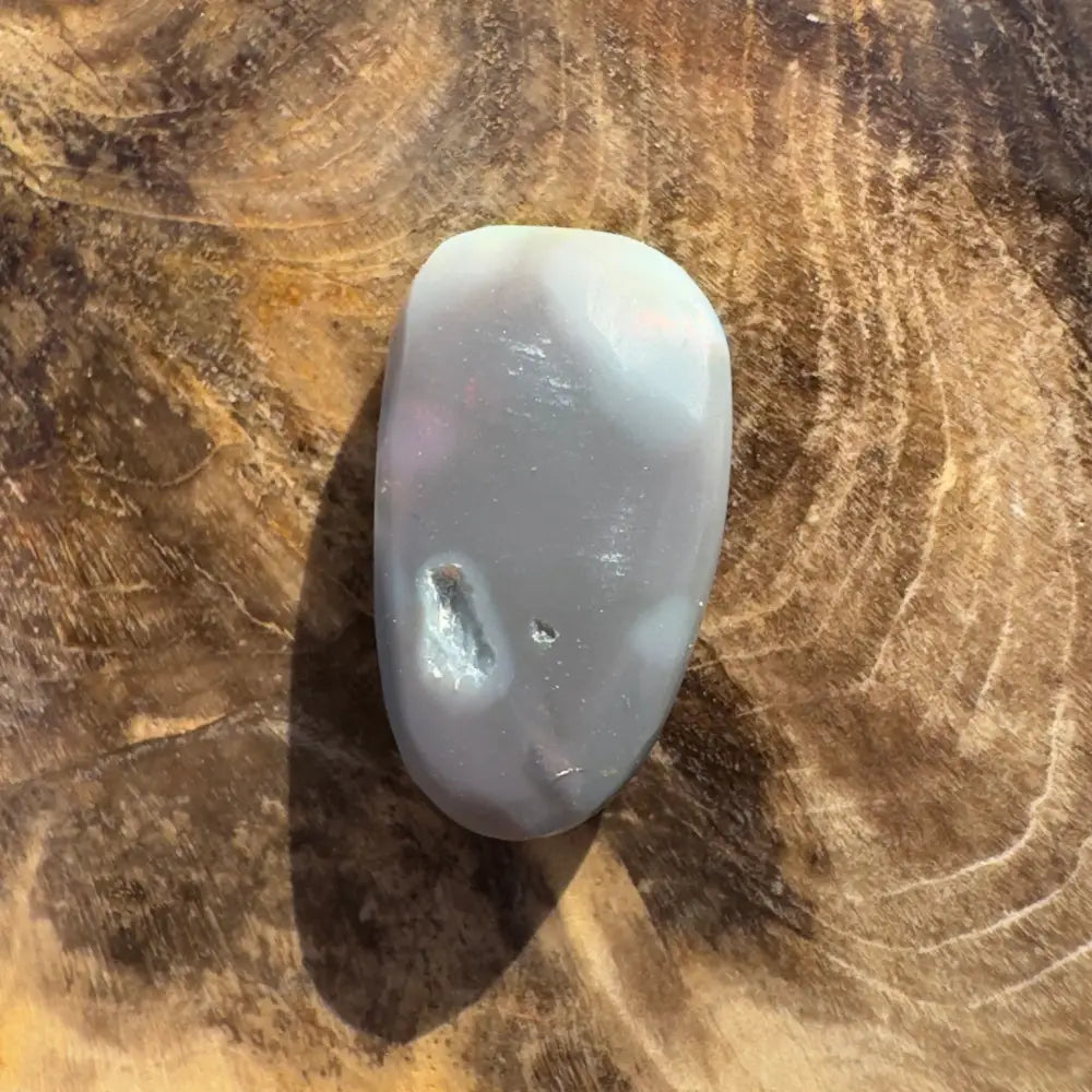 Polished gray stone with a small cavity, part of Hand-Cut Solid Lightning Ridge Semi Black Opal 2.8carat