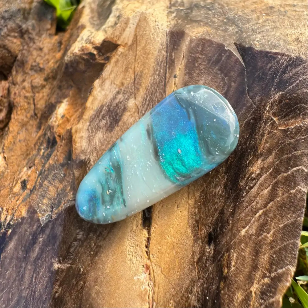 Polished iridescent blue and white semi black opal gemstone in product description