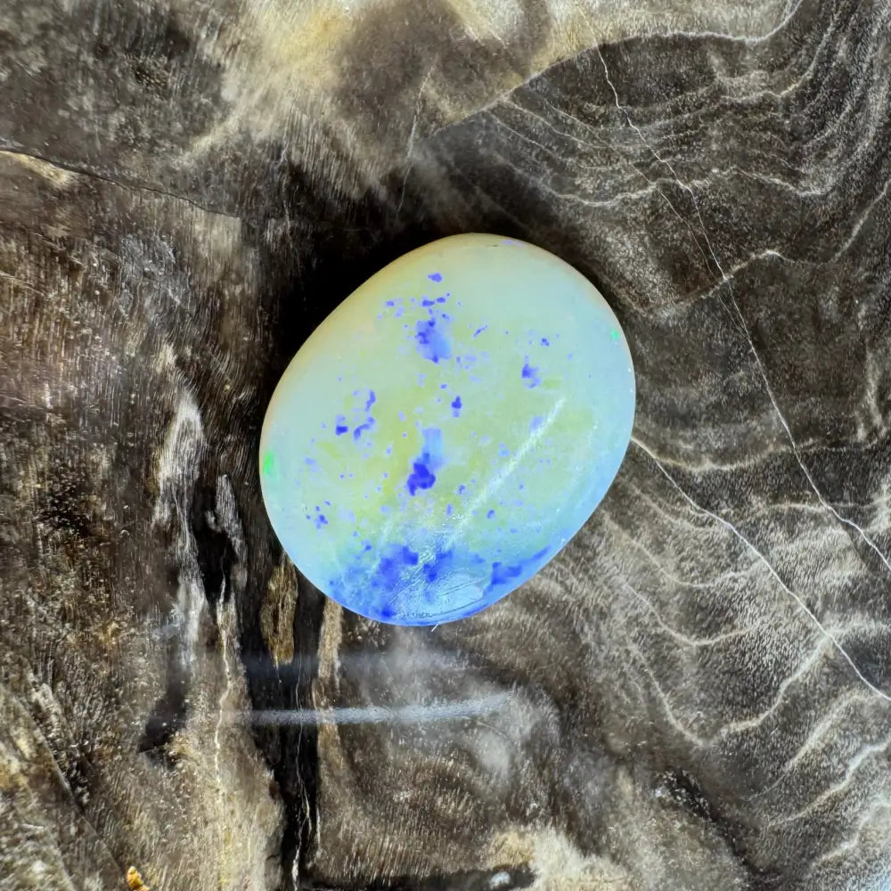 Oval opal cabochon with blue and yellow inclusions in the Lightning Ridge Opal 3.5 Carat Solid Hand-Cut