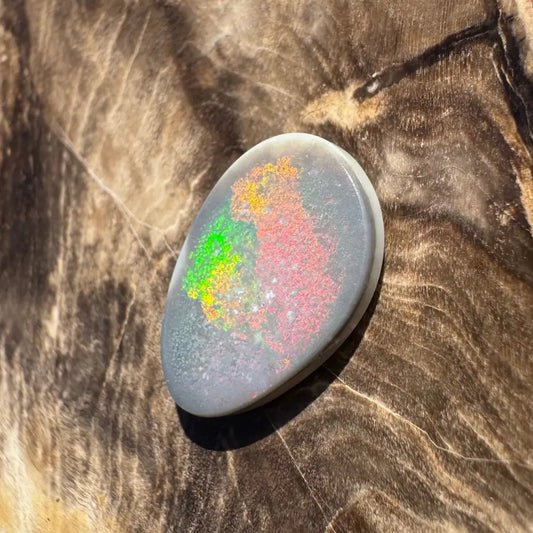 Polished Lightning Ridge semi black opal cabochon displaying vibrant color play in a 3.8carat solid hand-cut gemstone
