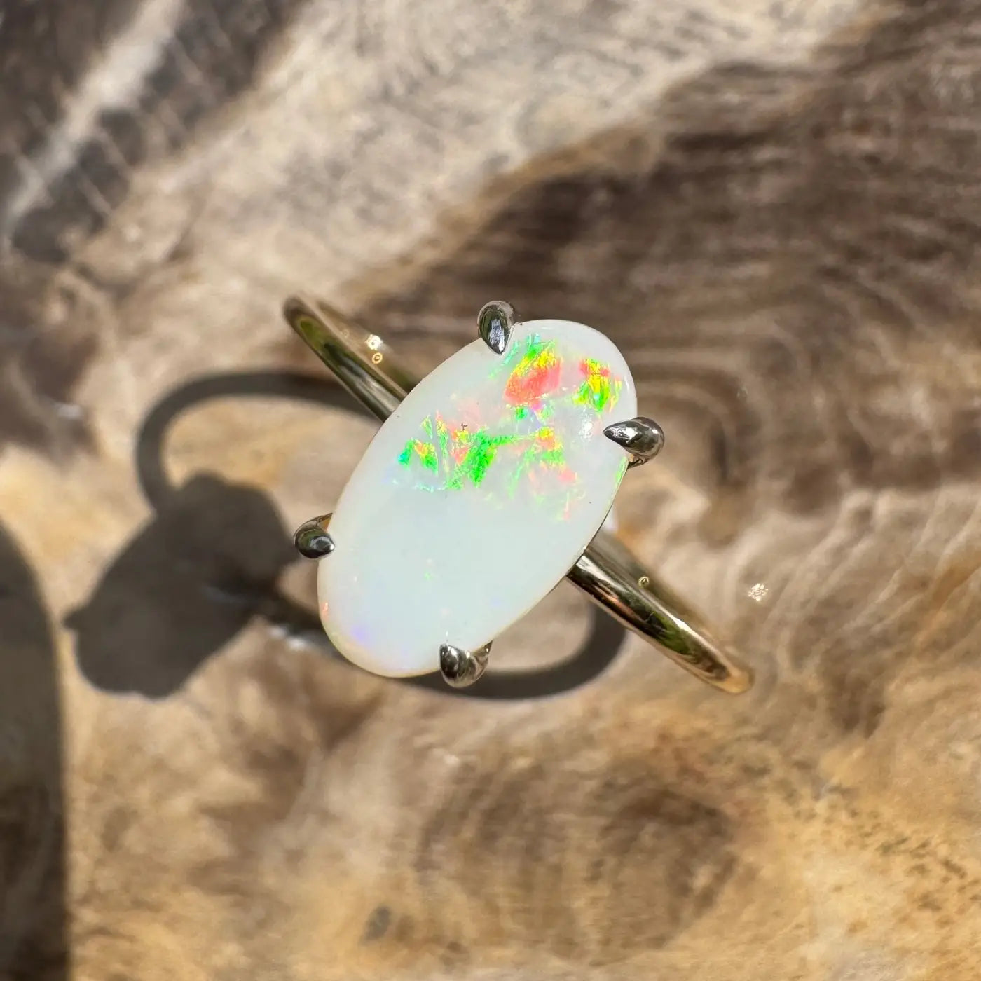 Oval opal ring with claw prongs from the Rolling Colours of Coober collection in yellow gold