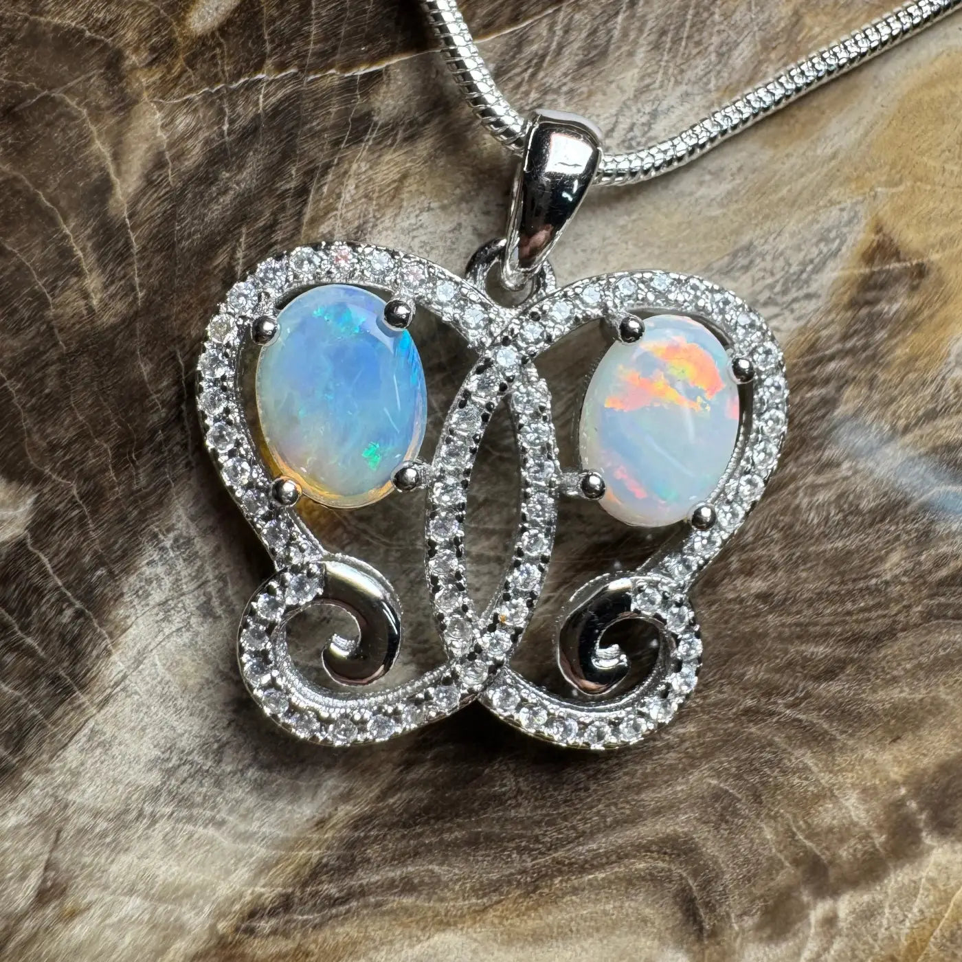 Butterfly-shaped pendant featuring Coober Pedy and Lightning Ridge Opal with cubic zirconia in sterling silver