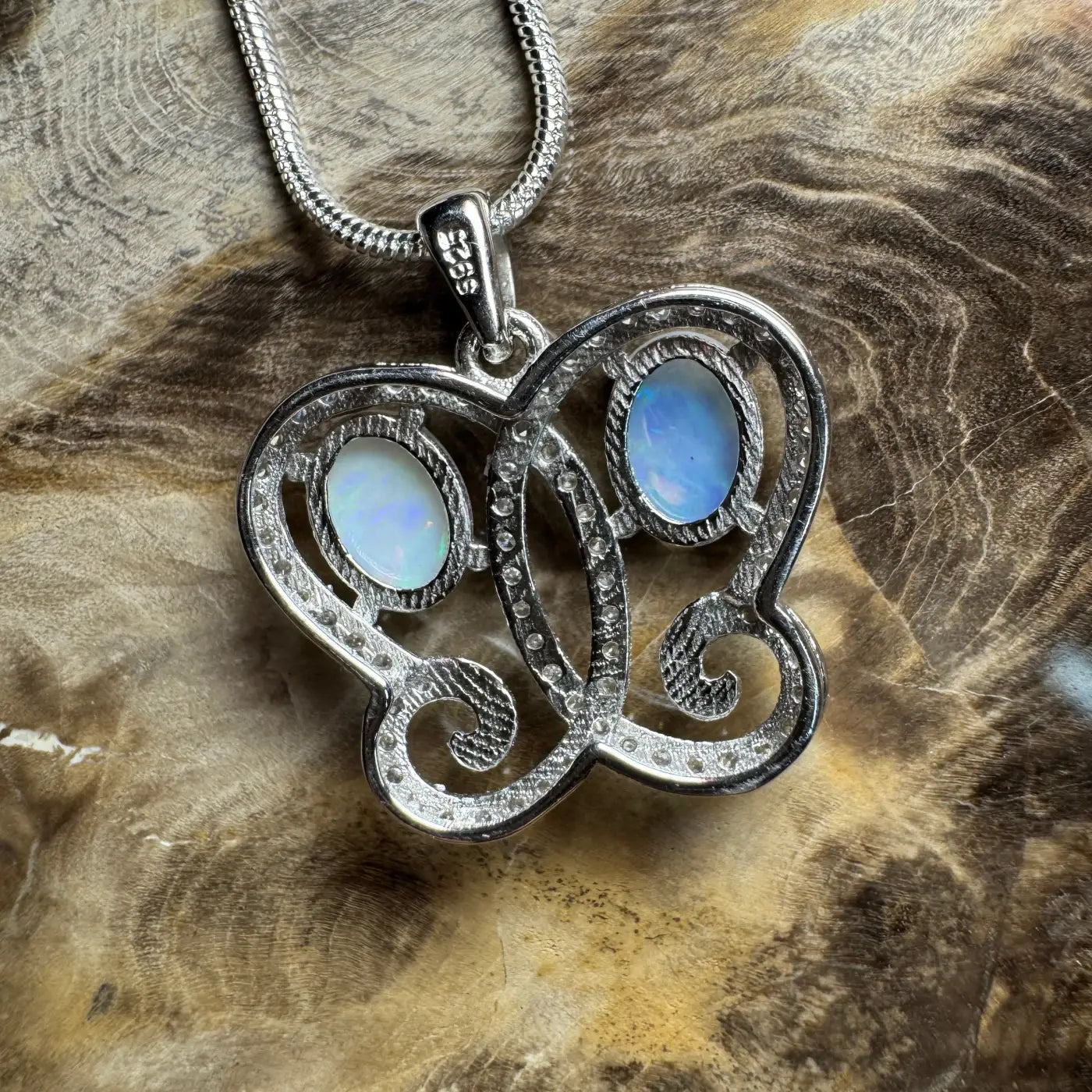 Silver butterfly pendant featuring Coober Pedy and Lightning Ridge opals with cubic zirconia