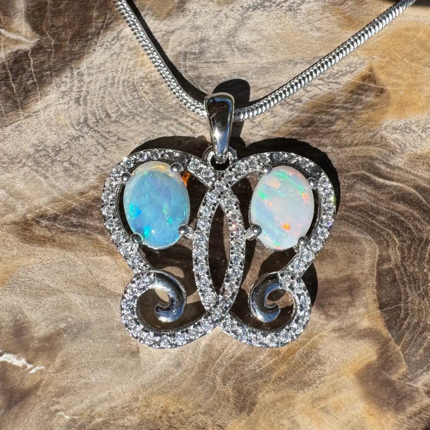Silver butterfly pendant with Coober Pedy and Lightning Ridge opals and cubic zirconia