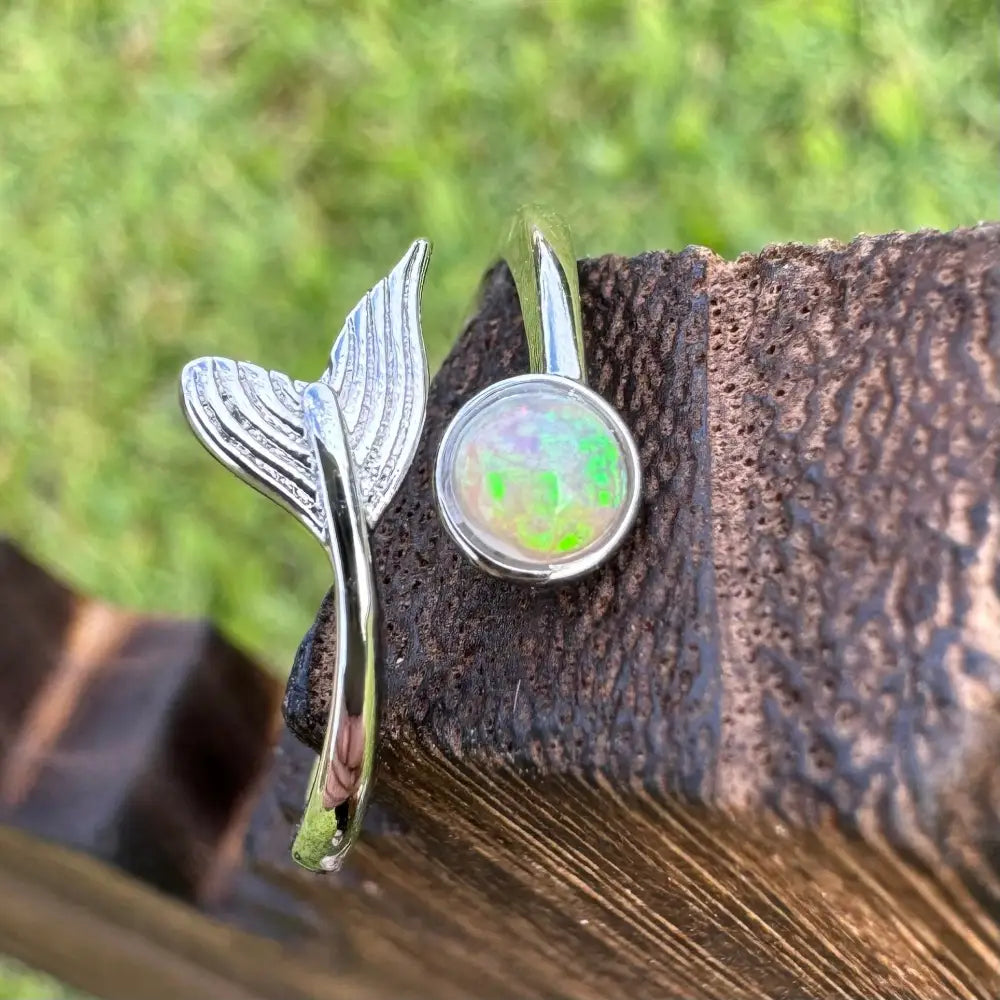 Silver mermaid tail and opal earrings in a handcrafted Lightning Ridge opal ring display